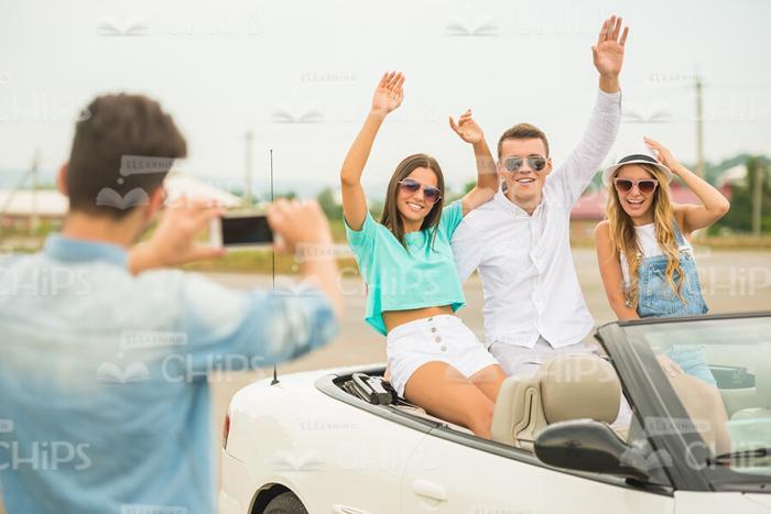 Young Guy Takes Picture Of Few His Friends Sitting In Convertible Car Stock Photo