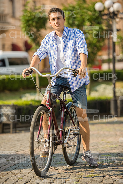 Casually Dressed Young Man Riding On Bicycle Stock Photo