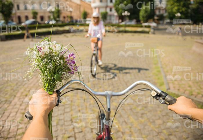 Man With Bouquet Riding On Bike First Person View Stock Photo