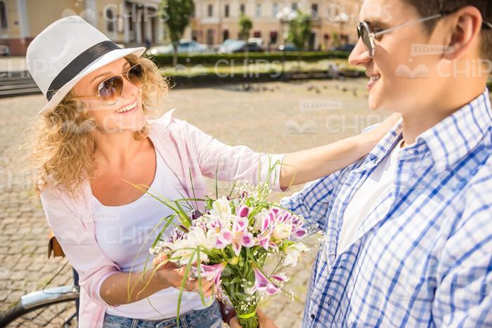 Man Presenting A Bouquet Of Flowers To His Girlfriend Stock Photo