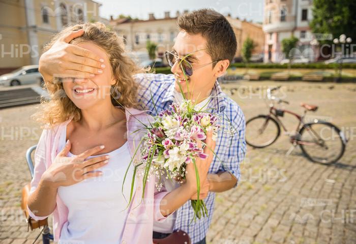 Man Covers Girl's Eyes And Ready To Give Bouquet Stock Photo