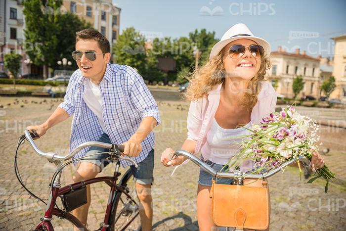 Cheerful Couple Having Fun While Riding On Their Bikes Stock Photo