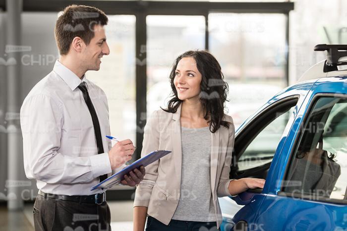 Young Woman And Vehicle Salesman Talking To Each Other Stock Photo