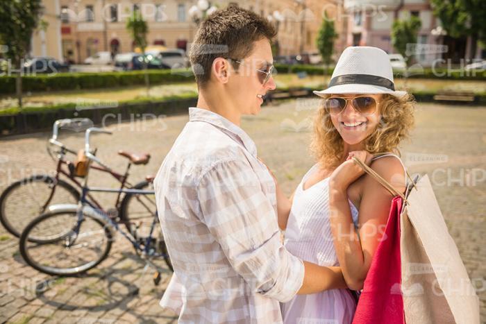 Young Man Hugging Her Girlfreind While She Holding Bags Stock Photo