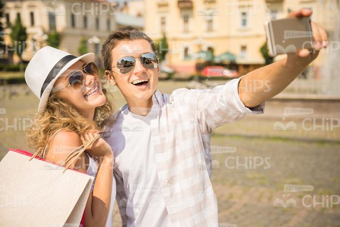 Cheerful Young Couple Taking Selfie On City Square After Shopping Stock Photo