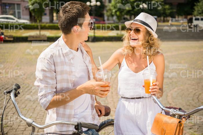 Handsome Couple Talking And Drinking Juice Stock Photo