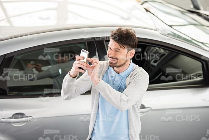 Young Man Taking Selfie At Car Dealer Shop Stock Photo