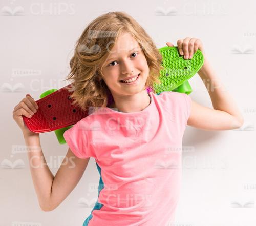 Pretty Young Girl Holding Skateboard Behind Her Head Stock Photo