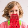 Happy Girl Covering Mouth With Skate Board Stock Photo