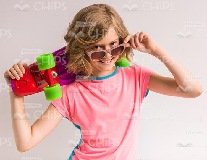 Pretty Girl In Sunglasses Holding Skateboard Stock Photo