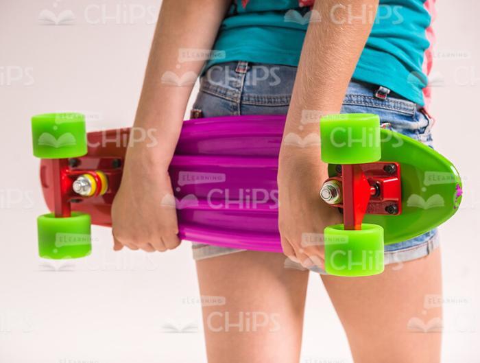 Girl's Hands Holding Skateboard Stock Photo