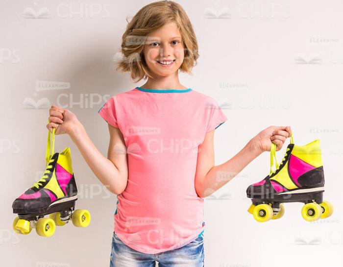 Smiling Girl Holding Roller Skates Stock Photo