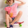 Cheerful Girl Sitting On Skateboard And Touching To Sunglasses Stock Photo