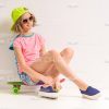 Young Female Skater Sitting On Her Skateboard Stock Photo