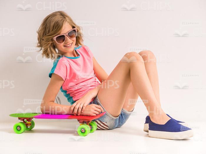 Nice Girl Sitting On Floor With Her Skateboard Stock Photo