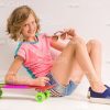 Handsome Girl Smiles And Sits On Floor Next To Her Skateboard Stock Photo