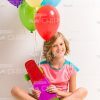 Young Girl Sitting On Floor And Holding Skateboard With Balloons Stock Photo