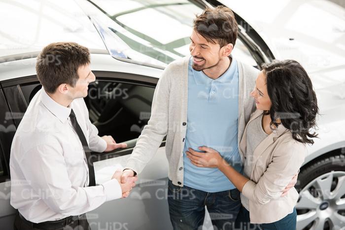 Car Salesman Talks With Nice Couple Stock Photo