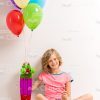 Cute Girl Sitting On Floop And Holding Skateboard With Balloons Stock Photo