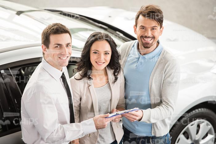 Glad Clients With Car Sales Assistant Stock Photo
