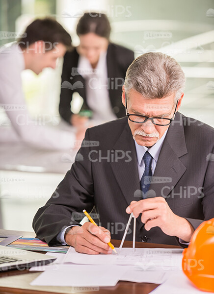 Mid Aged Engineer Drawing With Compass Stock Photo
