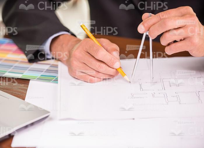 Man's Hands Holding Caliper Compass And Pencil While Making Drawing Stock Photo