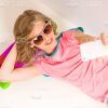 Young Girl Lying On Skateboard While Taking Selfie Stock Photo