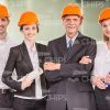 Team Of Successful Architects Wearing Orange Hard Hats Stock Photo