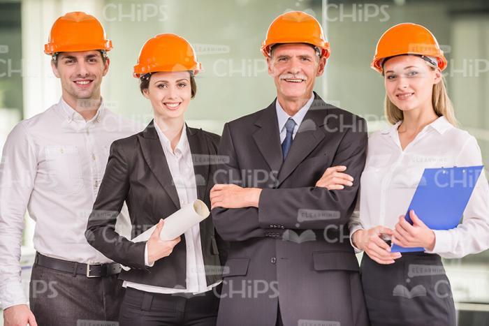 Team Of Successful Architects Wearing Orange Hard Hats Stock Photo