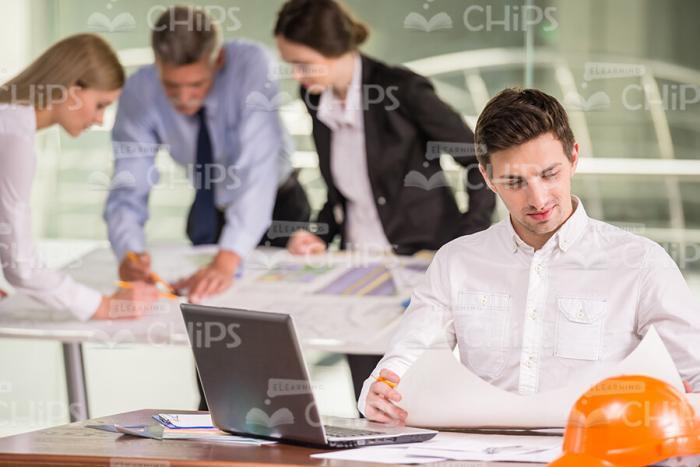 Man Working With Drawing At Office Stock Photo