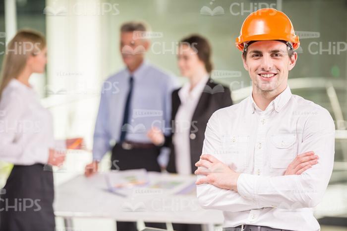 Young Businessman In Hard Hat Crosses Arms Stock Photo