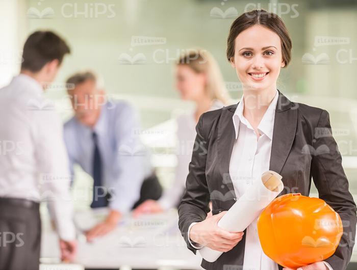 Smiling Woman With Hard Hat And Drawing Stock Photo