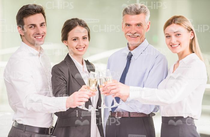 Business Team Clincking Glasses While Celebrating Stock Photo