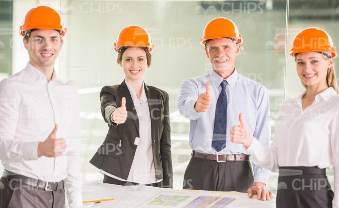 Business People Wearing Hard Hats And Showing Thumbs Up Stock Photo