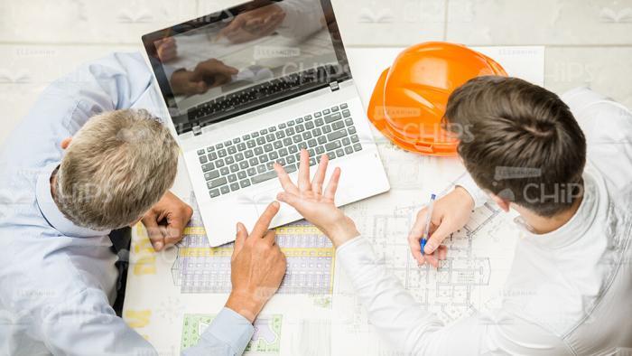 Two Architects Working With Laptop And Drawing View From Above Stock Photo