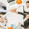 Four Engineers Put Hands Together View From Above Stock Photo