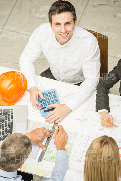 Smiling Engineer With Calculator Looks Up Stock Photo