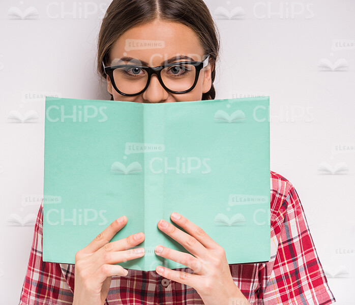Young Girl Covering Her Face With Book Stock Photo