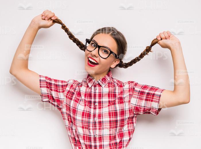 Cheerful Young Woman Holding Her Pigtails Stock Photo