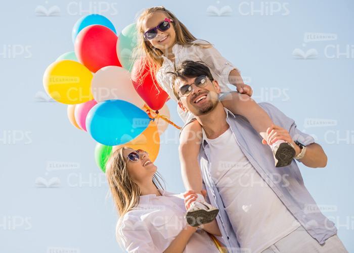 Happy Young Family On Blue Sky Background Stock Photo