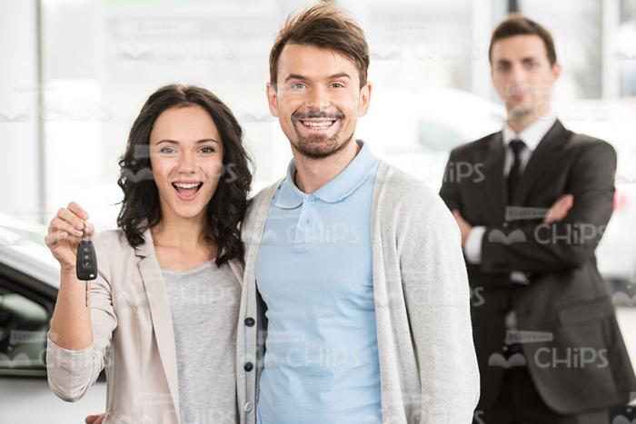 Excited Couple And Car Salesman Stock Photo