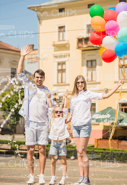 Happy Family With Bunch Of Balloons Making Greeting Gestures Stock Photo Happy Family With Bunch Of Balloons Making Greeting Gestures Stock Photo