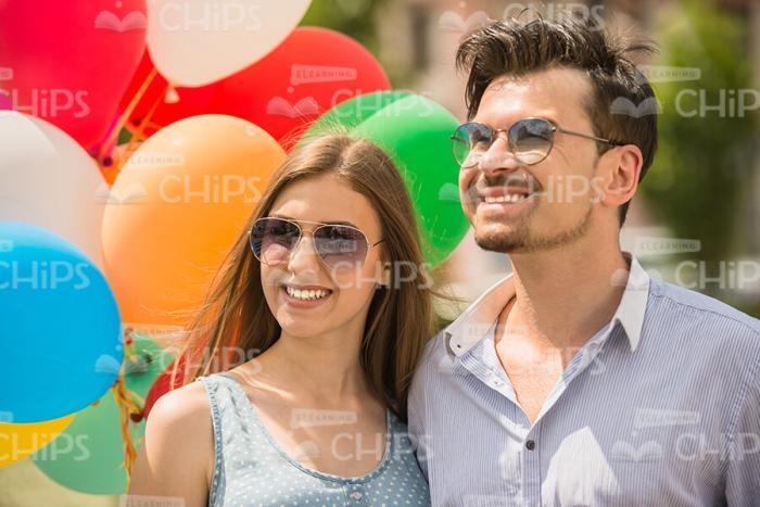 Smiling Couple With Balloons Walking Stock Photo