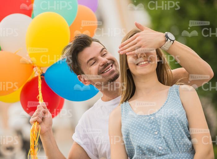 Happy Young Man Covering Woman's Eyes Stock Photo