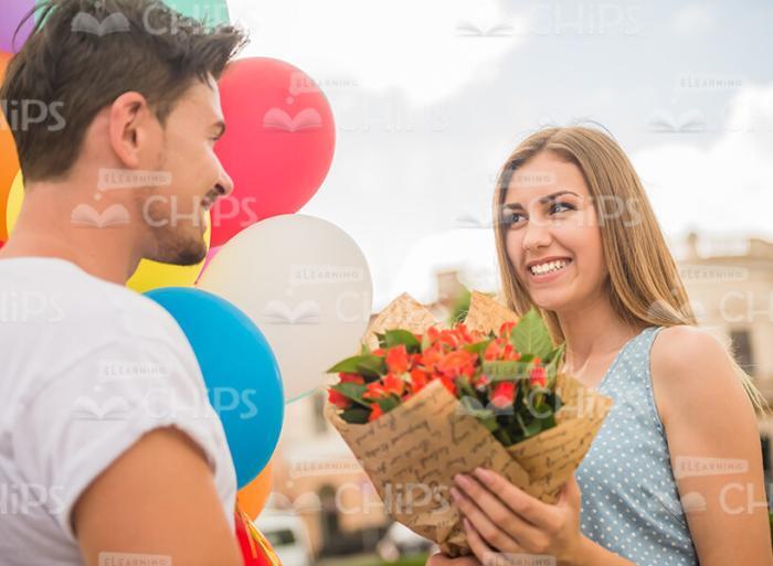 Happy Couple With Bouquet And Balloons Stock Photo