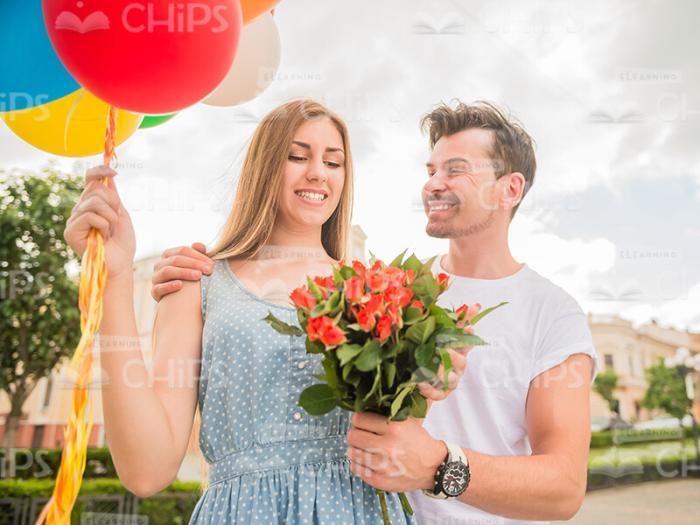Happy Young Man Giving Bouquet To His Wife Stock Photo