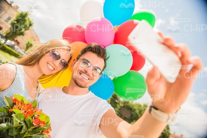 Smiling Couple With Balloons Taking Selfie Stock Photo