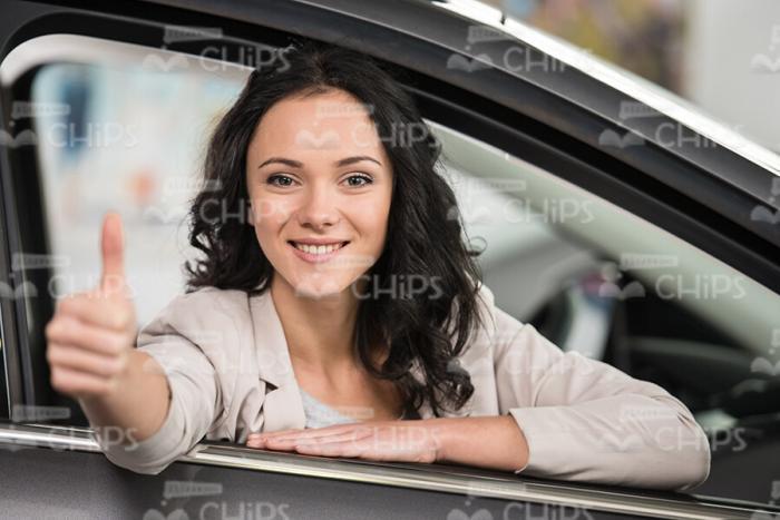Stock Photo Of Young Woman Sitting In Car And Showing The Thumb Up Gesture