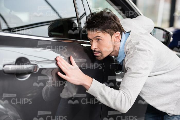Man Carefully Inspecting The Car Body Stock Photo