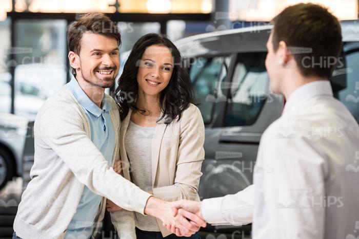 Male Buyer Shaking Hands With Car Salesman Stock Photo